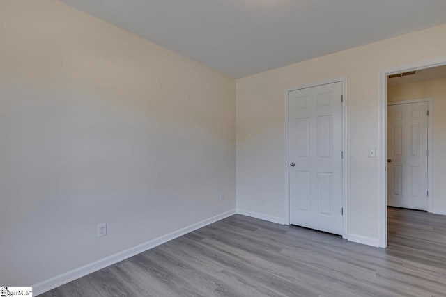 unfurnished bedroom featuring light hardwood / wood-style floors and a closet