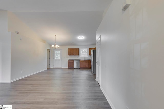 unfurnished living room featuring hardwood / wood-style flooring, a notable chandelier, and sink