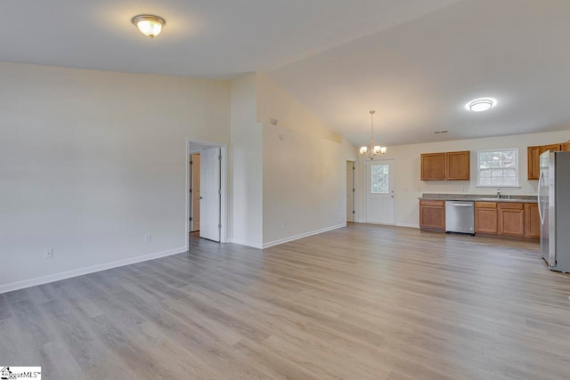 interior space with an inviting chandelier, light hardwood / wood-style flooring, lofted ceiling, and sink