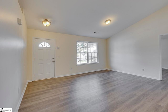 entryway with light hardwood / wood-style flooring, a wealth of natural light, and lofted ceiling