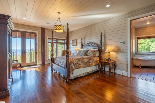 bedroom with access to exterior, wood walls, dark hardwood / wood-style flooring, and french doors