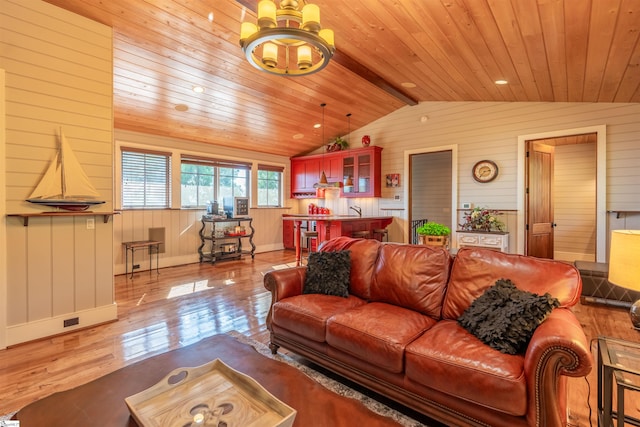 living room with an inviting chandelier, vaulted ceiling with beams, wood walls, light hardwood / wood-style floors, and wood ceiling