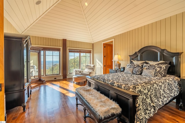 bedroom featuring dark hardwood / wood-style flooring, high vaulted ceiling, and wooden walls