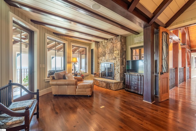 living room featuring beamed ceiling, wood walls, a fireplace, wood ceiling, and hardwood / wood-style flooring