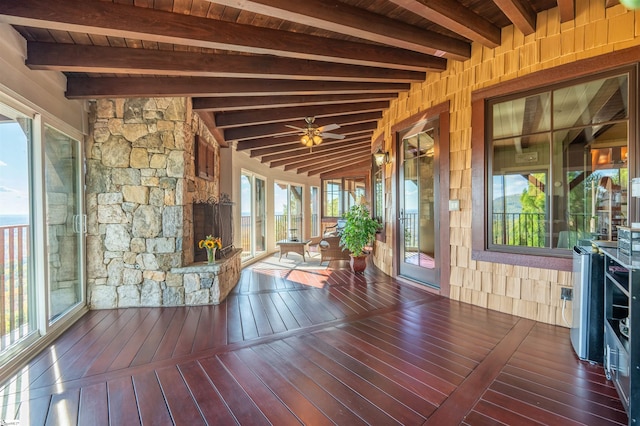 unfurnished sunroom with vaulted ceiling with beams, ceiling fan, and wood ceiling