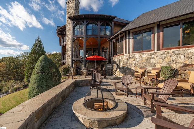 view of patio / terrace with a balcony and a fire pit