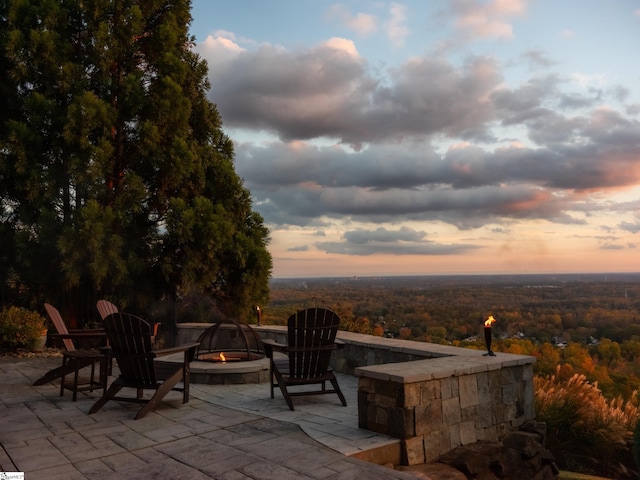 patio terrace at dusk featuring an outdoor fire pit