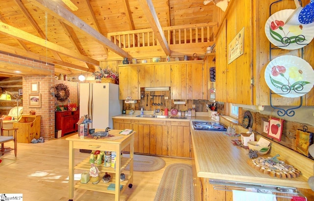 kitchen featuring beam ceiling, stainless steel gas cooktop, wooden ceiling, and light hardwood / wood-style floors