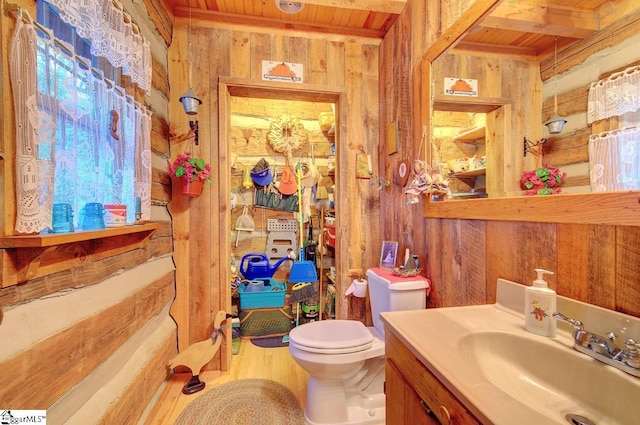 bathroom featuring vanity, wooden ceiling, wooden walls, toilet, and wood-type flooring