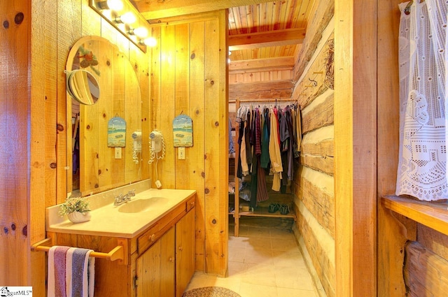 bathroom with tile patterned flooring, vanity, wooden ceiling, and wood walls