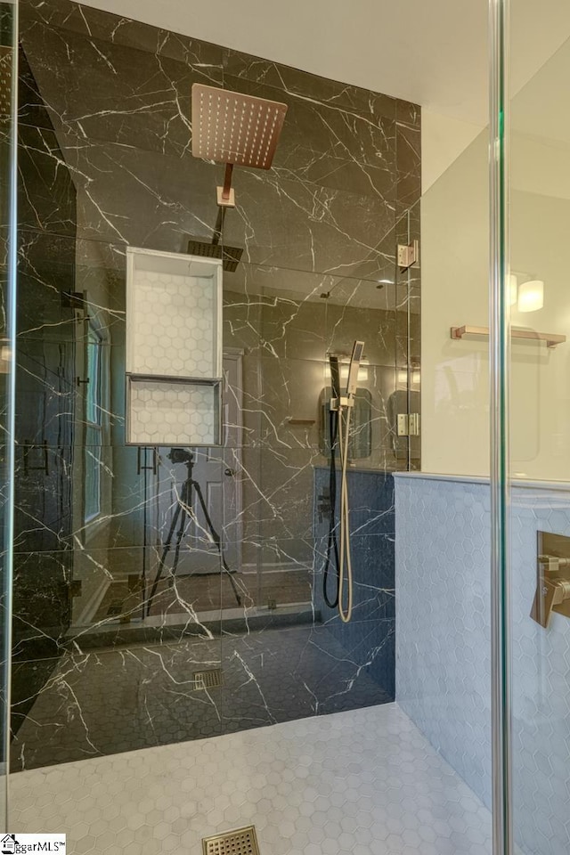 bathroom featuring walk in shower and tile walls