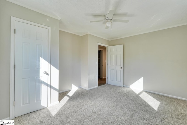 carpeted empty room featuring ceiling fan and ornamental molding