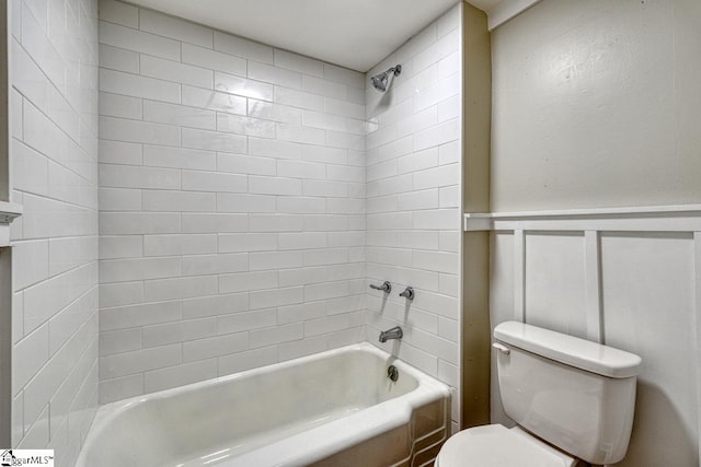 bathroom featuring tiled shower / bath combo and toilet