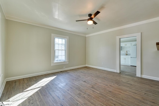 spare room with wood-type flooring, ceiling fan, and ornamental molding