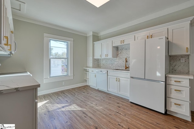 kitchen featuring decorative backsplash, white cabinets, light hardwood / wood-style floors, and white appliances