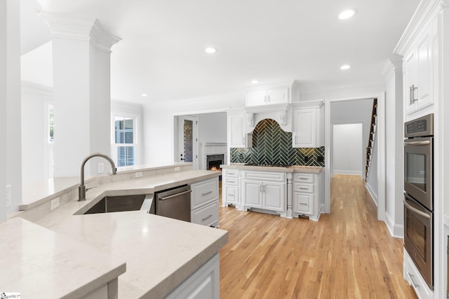 kitchen featuring sink, white cabinets, stainless steel appliances, and light wood-type flooring