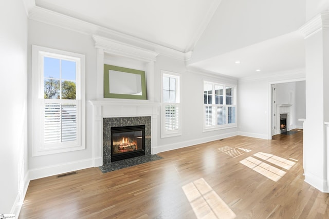 unfurnished living room with a fireplace, light hardwood / wood-style floors, plenty of natural light, and crown molding