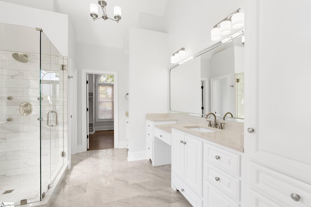 bathroom with a chandelier, vanity, and a shower with door