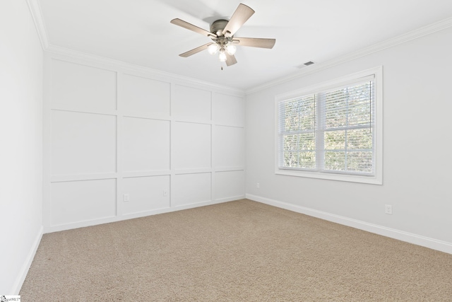 carpeted spare room with ceiling fan and ornamental molding