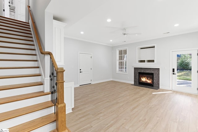 unfurnished living room with crown molding, light hardwood / wood-style flooring, and ceiling fan