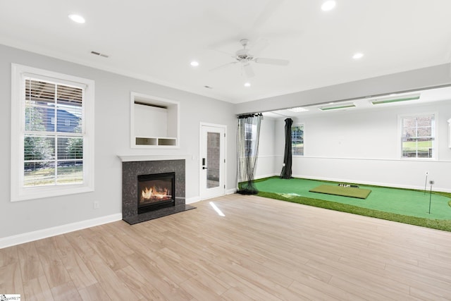 rec room with golf simulator, ceiling fan, and light hardwood / wood-style floors