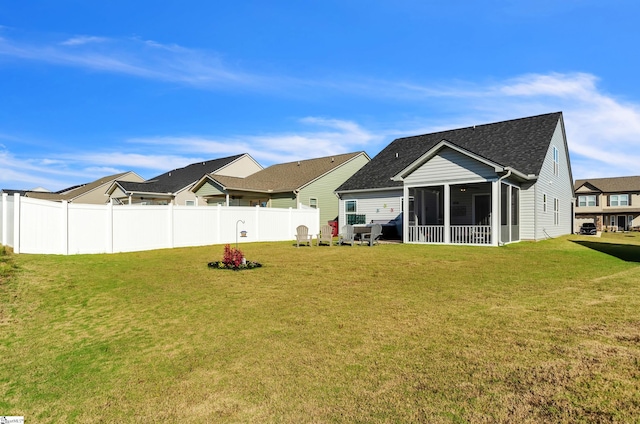 back of property with a lawn and a sunroom