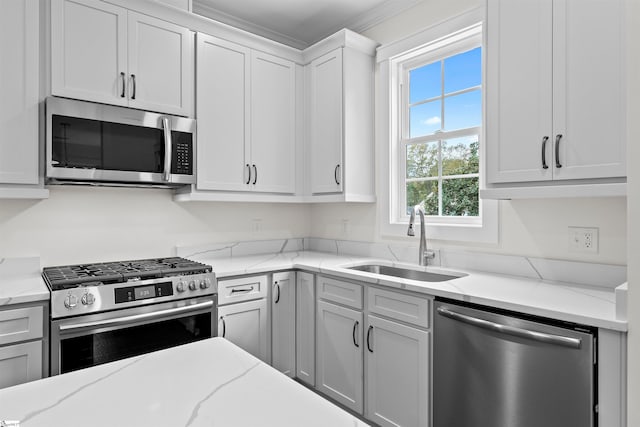 kitchen featuring white cabinetry, sink, light stone counters, and appliances with stainless steel finishes