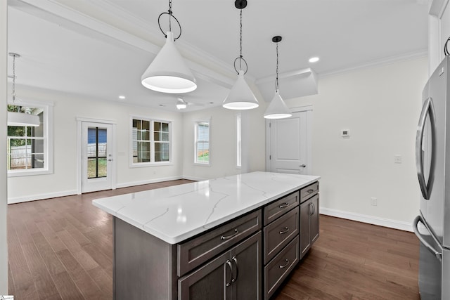 kitchen with pendant lighting, a center island, dark wood-type flooring, ceiling fan, and dark brown cabinetry