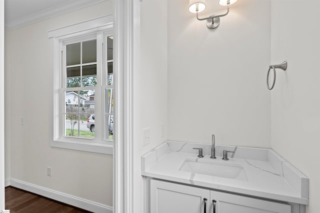 bathroom with hardwood / wood-style floors, vanity, and ornamental molding