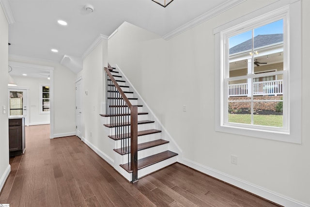 stairs with hardwood / wood-style floors, crown molding, and a healthy amount of sunlight