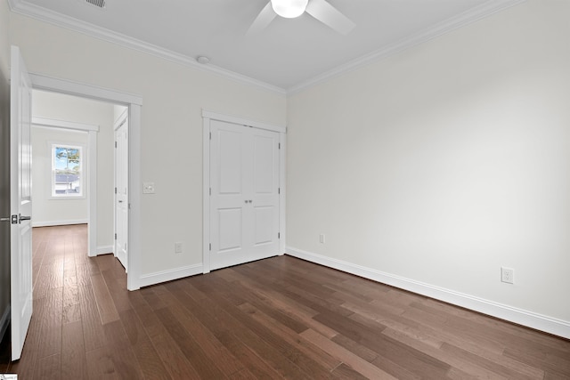 unfurnished bedroom featuring ceiling fan, dark hardwood / wood-style flooring, ornamental molding, and a closet