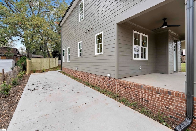 view of side of property with ceiling fan and a patio area