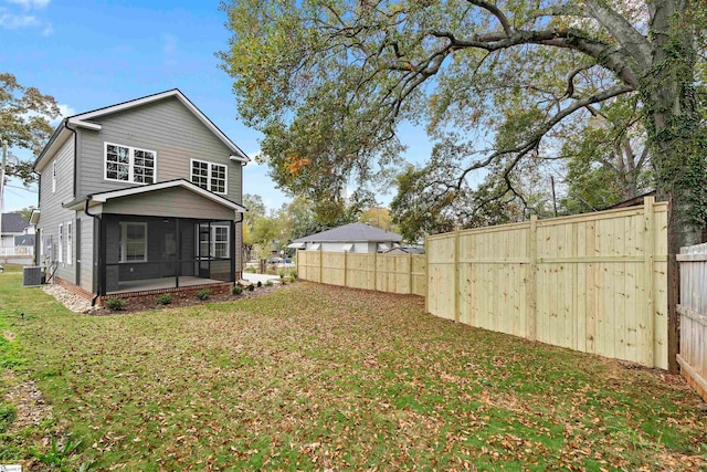 back of property featuring a sunroom and a yard