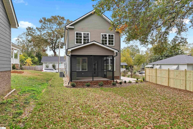 back of property with central air condition unit, a lawn, and a sunroom