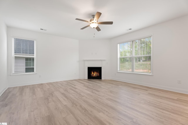 3361 Navin Trl, Roebuck, SC 29376 - unfurnished living room featuring light wood-type flooring, a ceiling fan, a warm lit fireplace, and baseboards