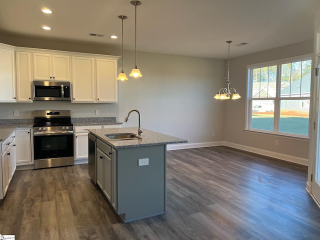 kitchen with white cabinetry, sink, stainless steel appliances, and decorative light fixtures