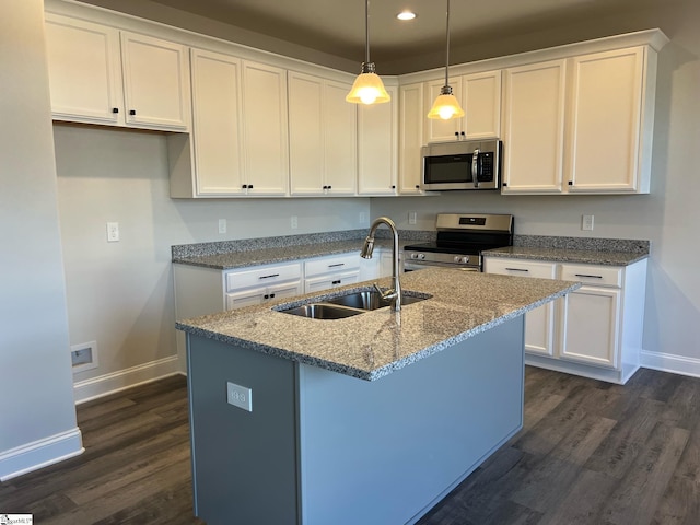 kitchen featuring white cabinets, stainless steel appliances, light stone counters, and sink