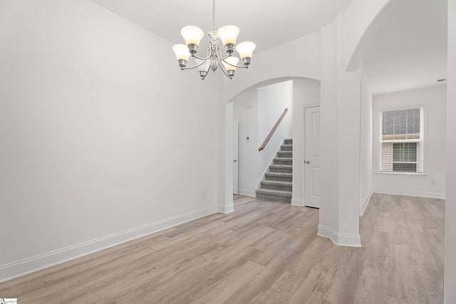 3361 Navin Trl, Roebuck, SC 29376 - spare room with arched walkways, a chandelier, light wood-style flooring, stairway, and baseboards