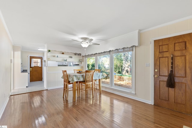 dining space featuring light wood-type flooring, ceiling fan, and crown molding