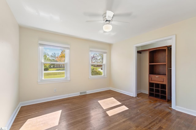 unfurnished bedroom featuring ceiling fan, a closet, and dark hardwood / wood-style floors