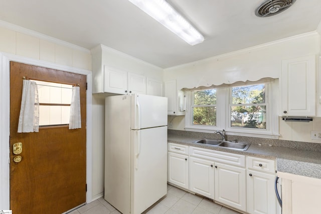 kitchen featuring crown molding, sink, light tile patterned floors, white refrigerator, and white cabinetry