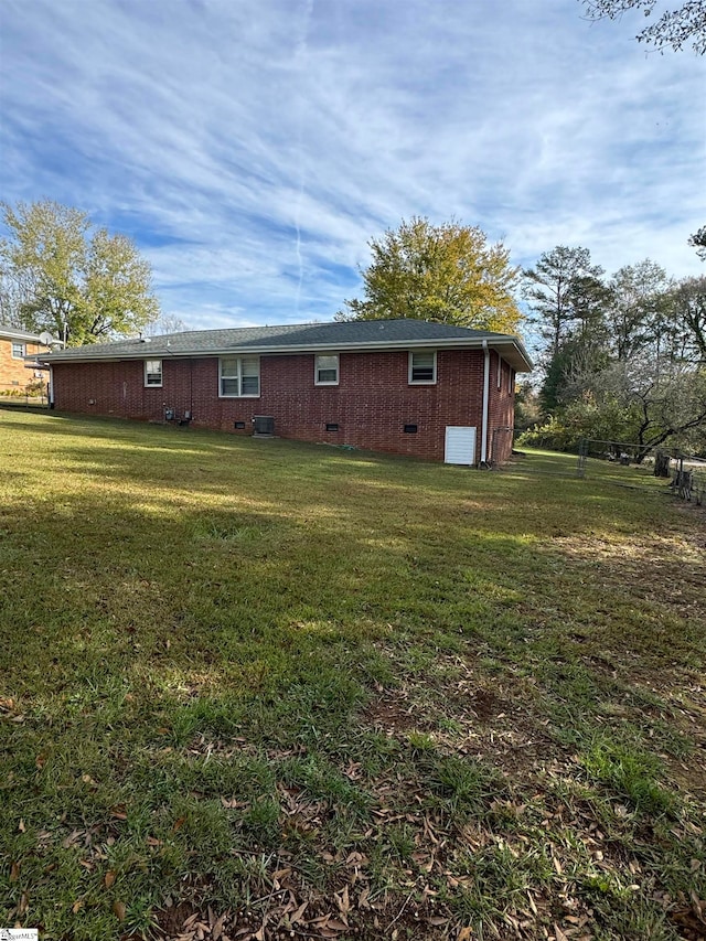 back of property featuring central AC unit and a yard