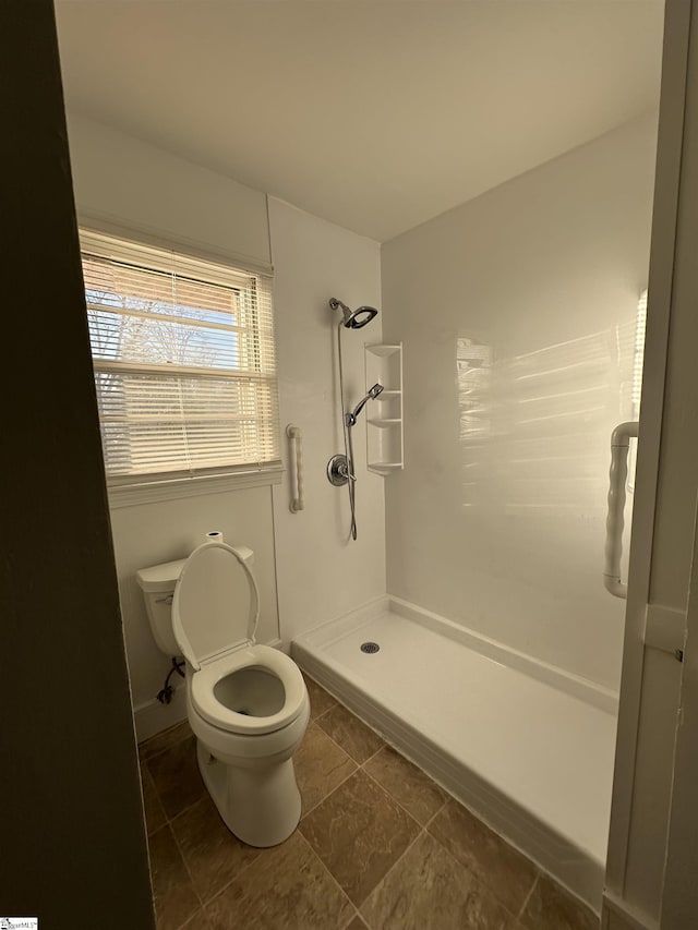 bathroom featuring a shower and toilet