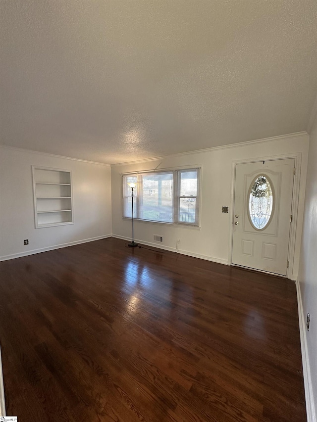 foyer entrance with a textured ceiling, dark hardwood / wood-style floors, and a healthy amount of sunlight