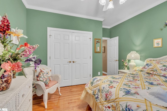 bedroom featuring ceiling fan, a closet, crown molding, and wood finished floors