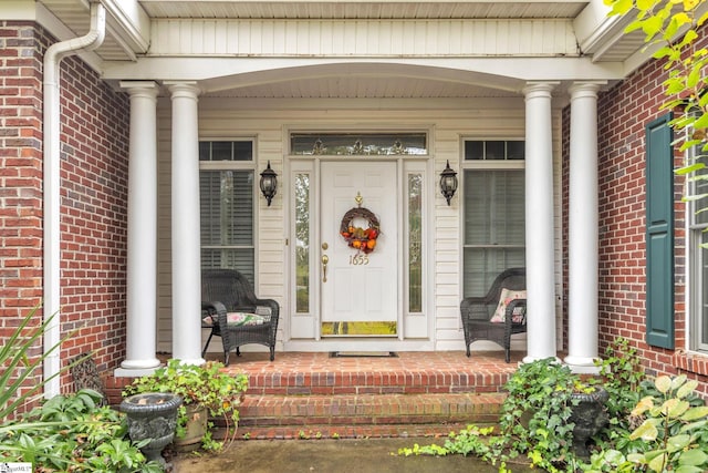 property entrance featuring a porch and brick siding