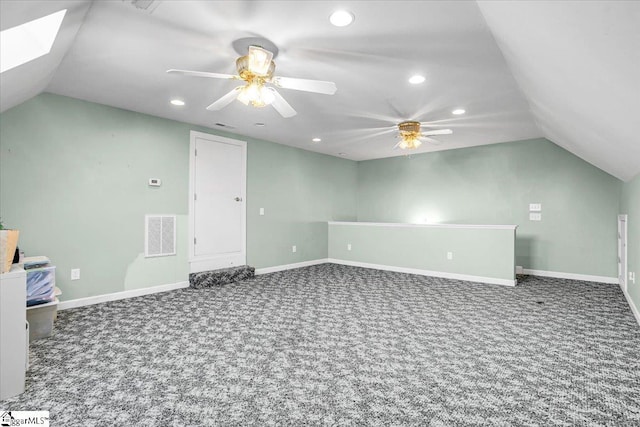 additional living space featuring vaulted ceiling with skylight, carpet flooring, and baseboards