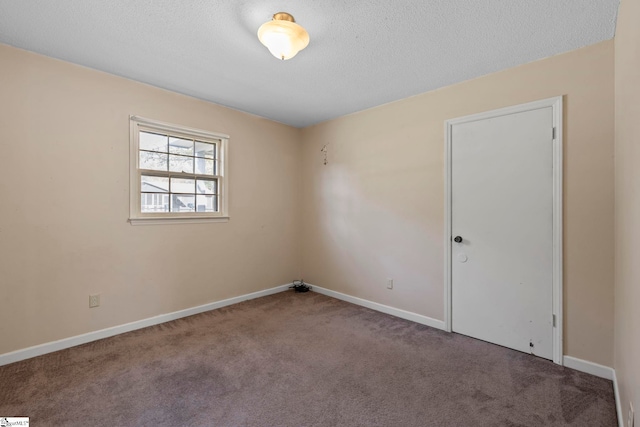 empty room with carpet and a textured ceiling