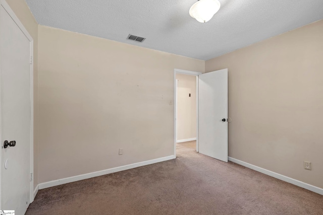 unfurnished room featuring a textured ceiling and carpet floors