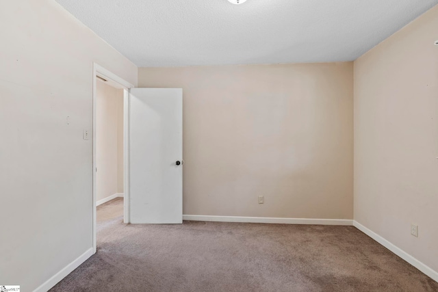 carpeted spare room with a textured ceiling